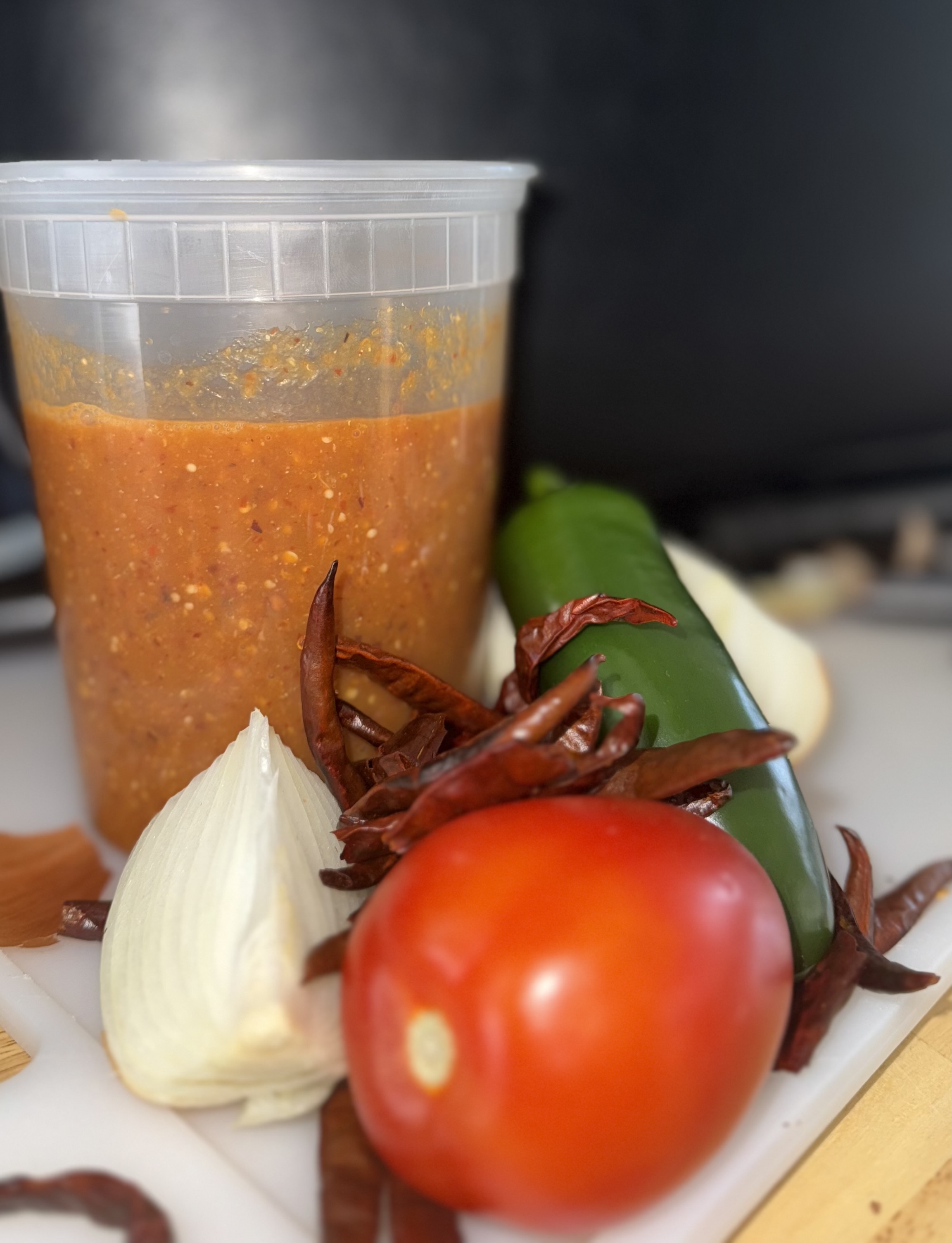 Fresh house salsa ingredients — tomato, jalapeño, garlic, dried chiles